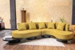 Caldris L shape curved sofa in mustard fabric with low seating and modern rounded base design in living room setting