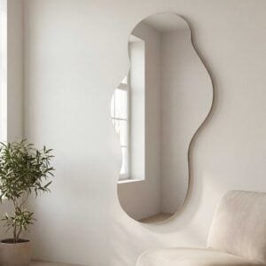 Morano frameless wall mirror with organic curved shape in full length design reflecting natural light in modern neutral interior setting