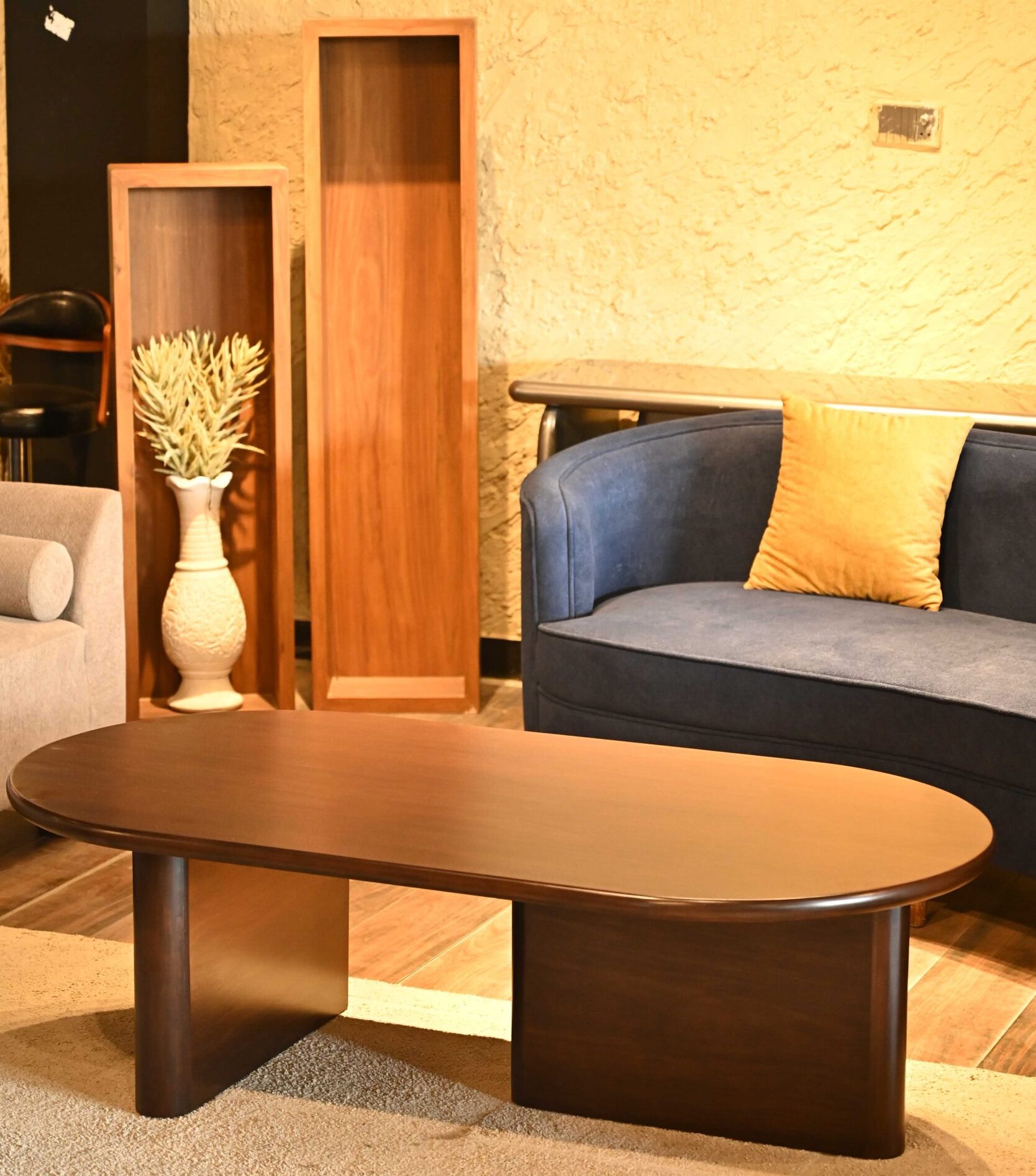 Modern elliptic oval wood center table with thick architectural slab legs by Renome